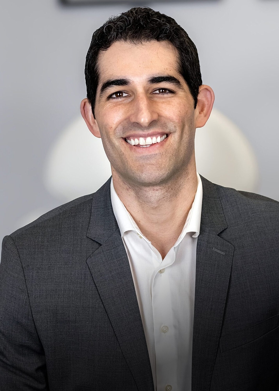 Smiling man in a suit, professional setting.