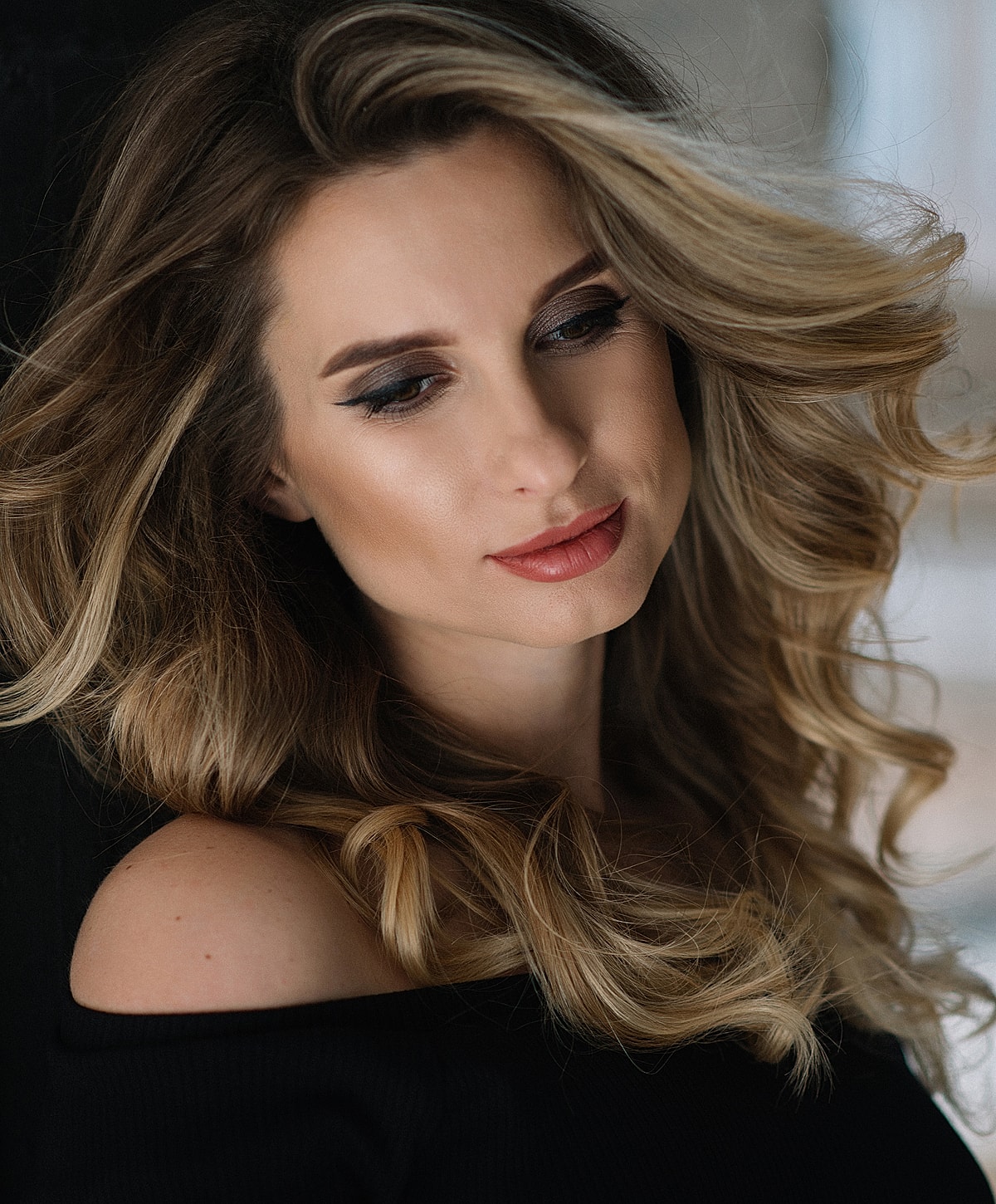 Woman with wavy hair and subtle makeup.