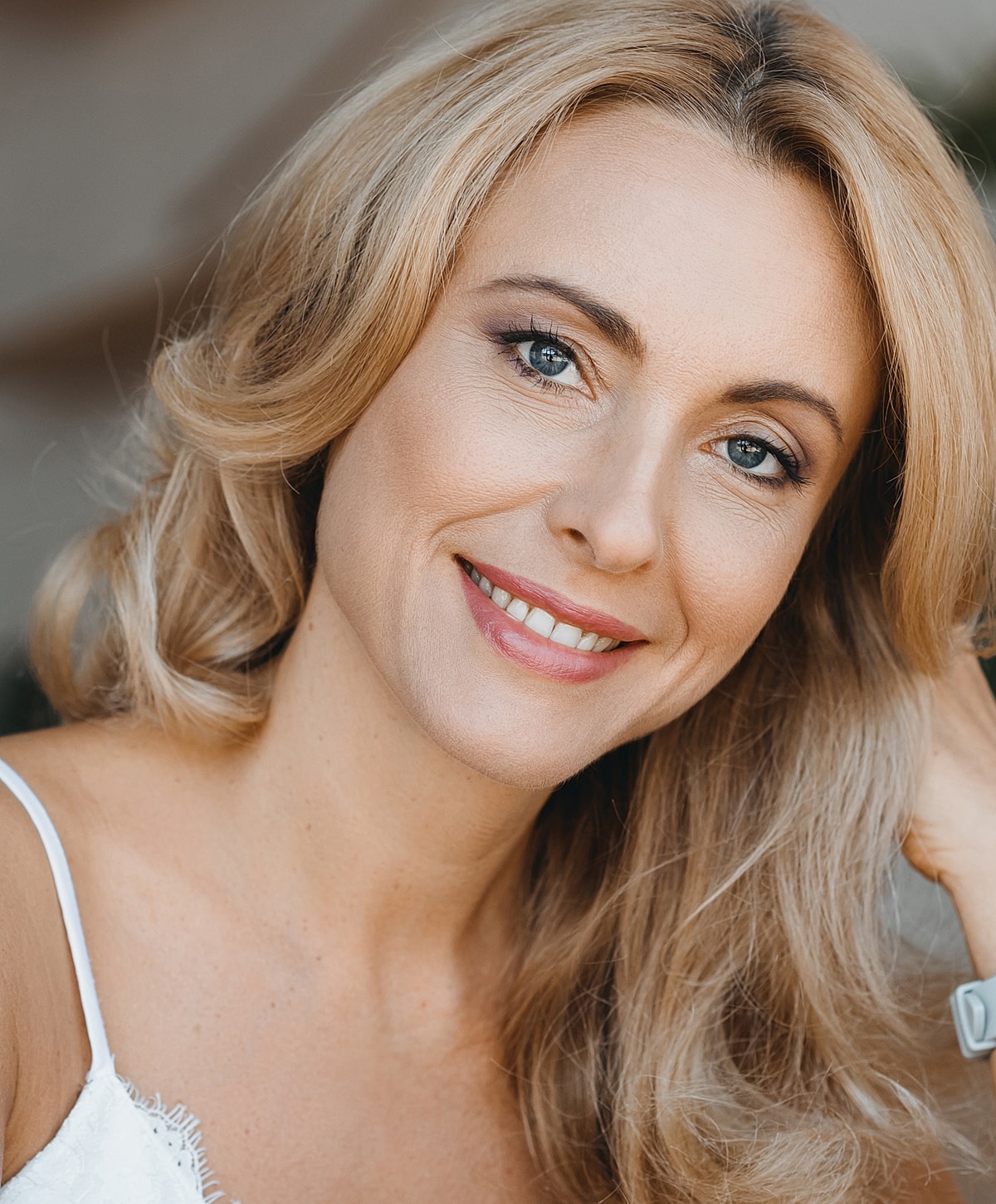 Smiling woman with blonde hair and blue eyes.