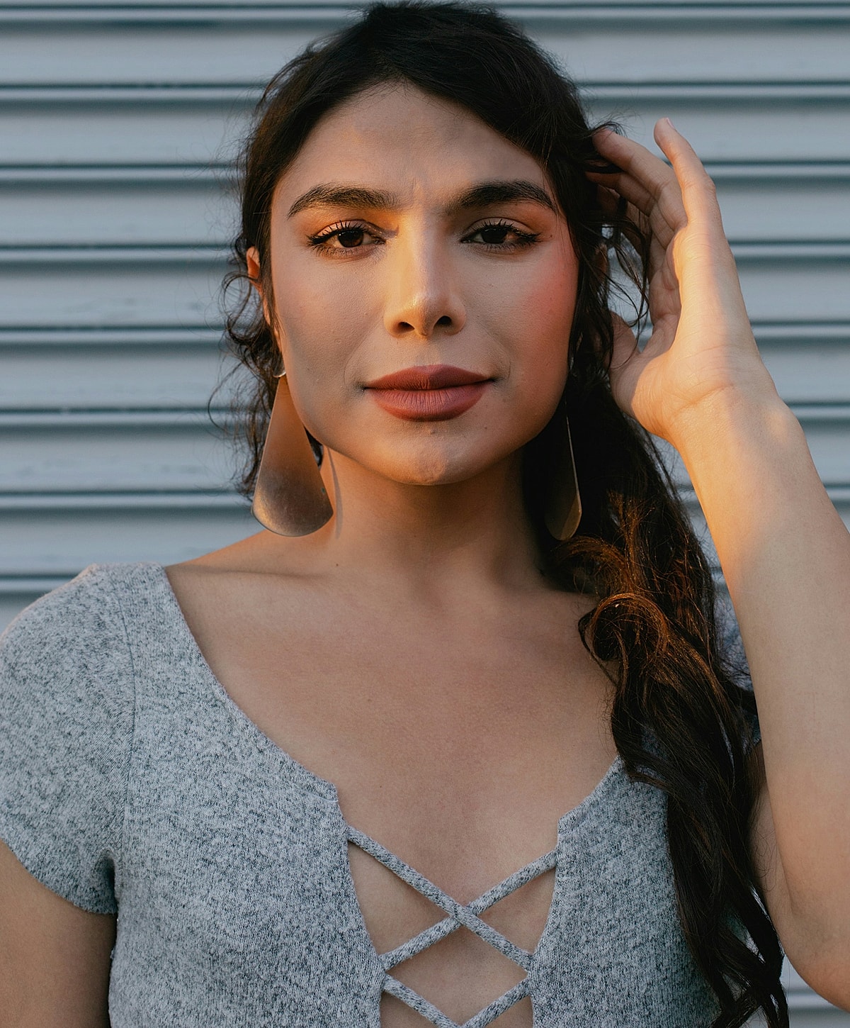 Person with braided hair and oversized earrings.