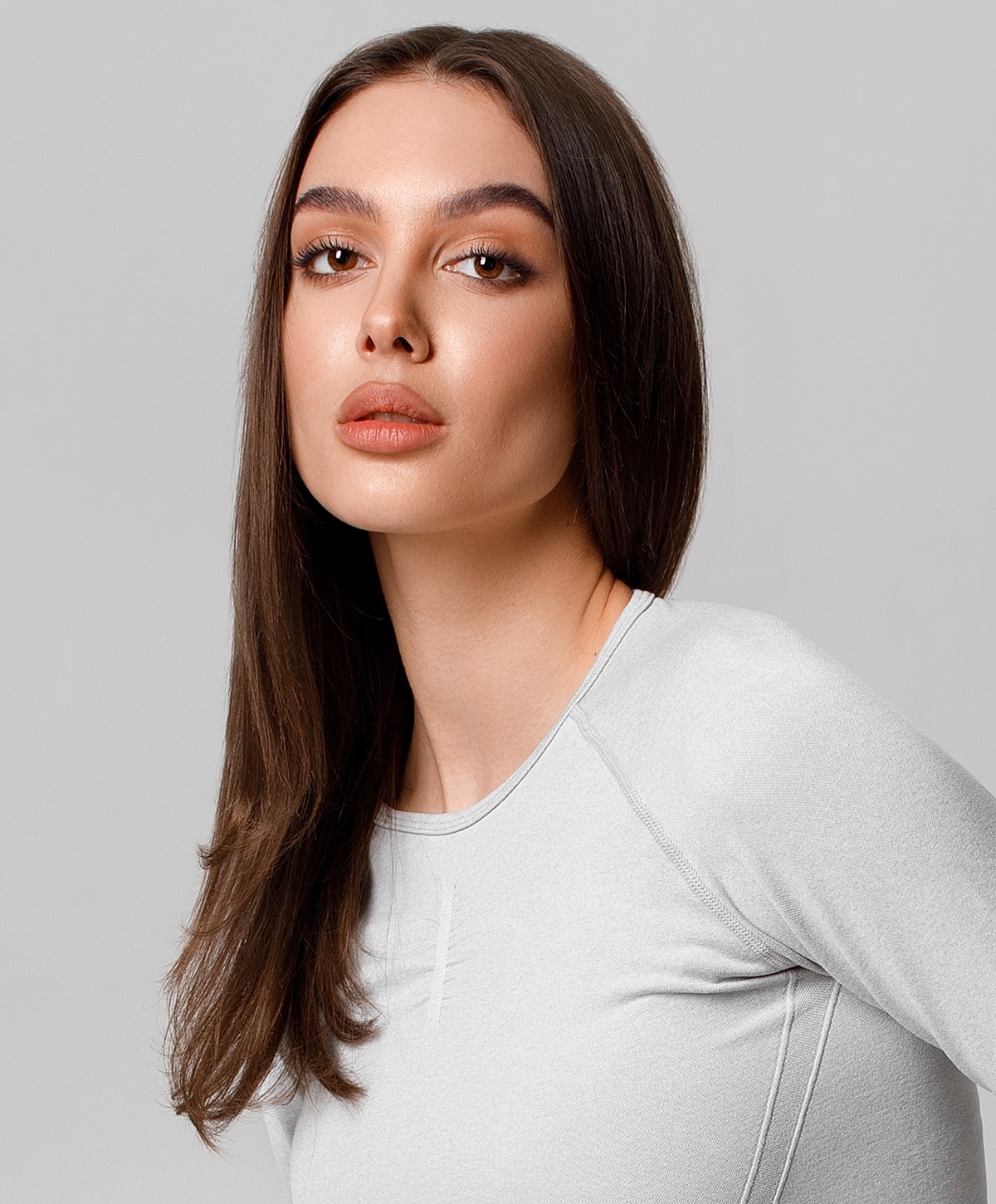 Model with long hair in gray top.