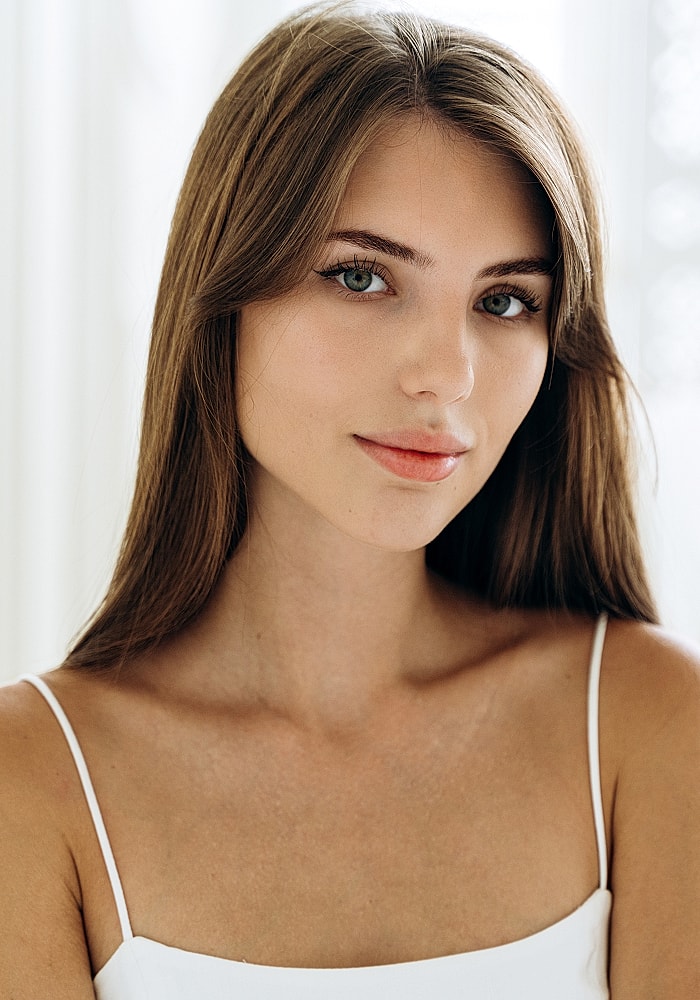 Close-up portrait of a young woman smiling.