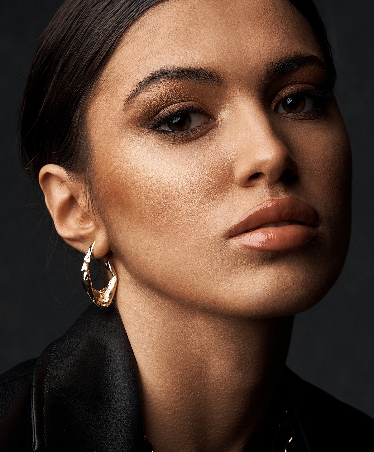 Close-up portrait of a young woman with earrings.