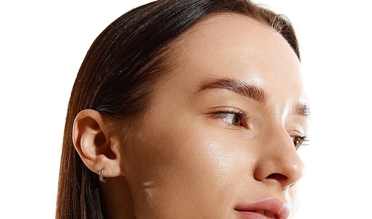 Model showcasing elegant earrings and natural beauty.