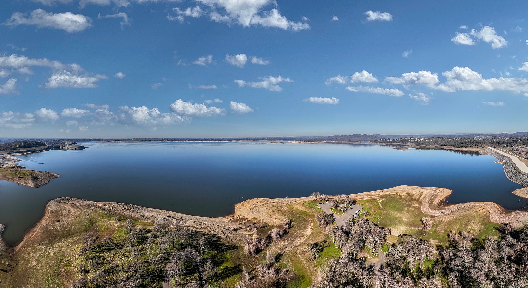 Panoramic view of tranquil lake and blue sky.