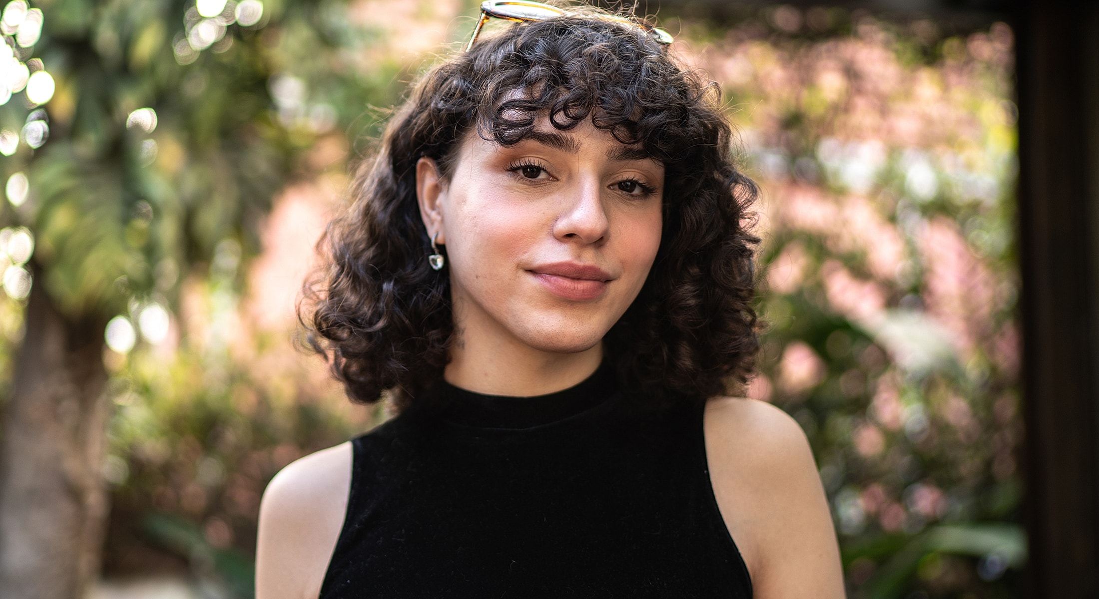 Person with curly hair in a natural setting.